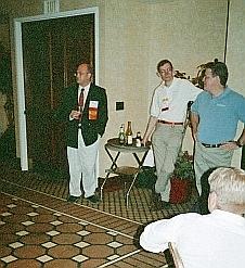 Thomas Sterling (left) gives the opening speach at the First Annual Extreme Beowulf Bash at SuperComputing '99.  Two of the Bash sponsors, Jim Cownie of Etnus (center) and Douglas Eadline of Paralogic, Inc. stand to his left.